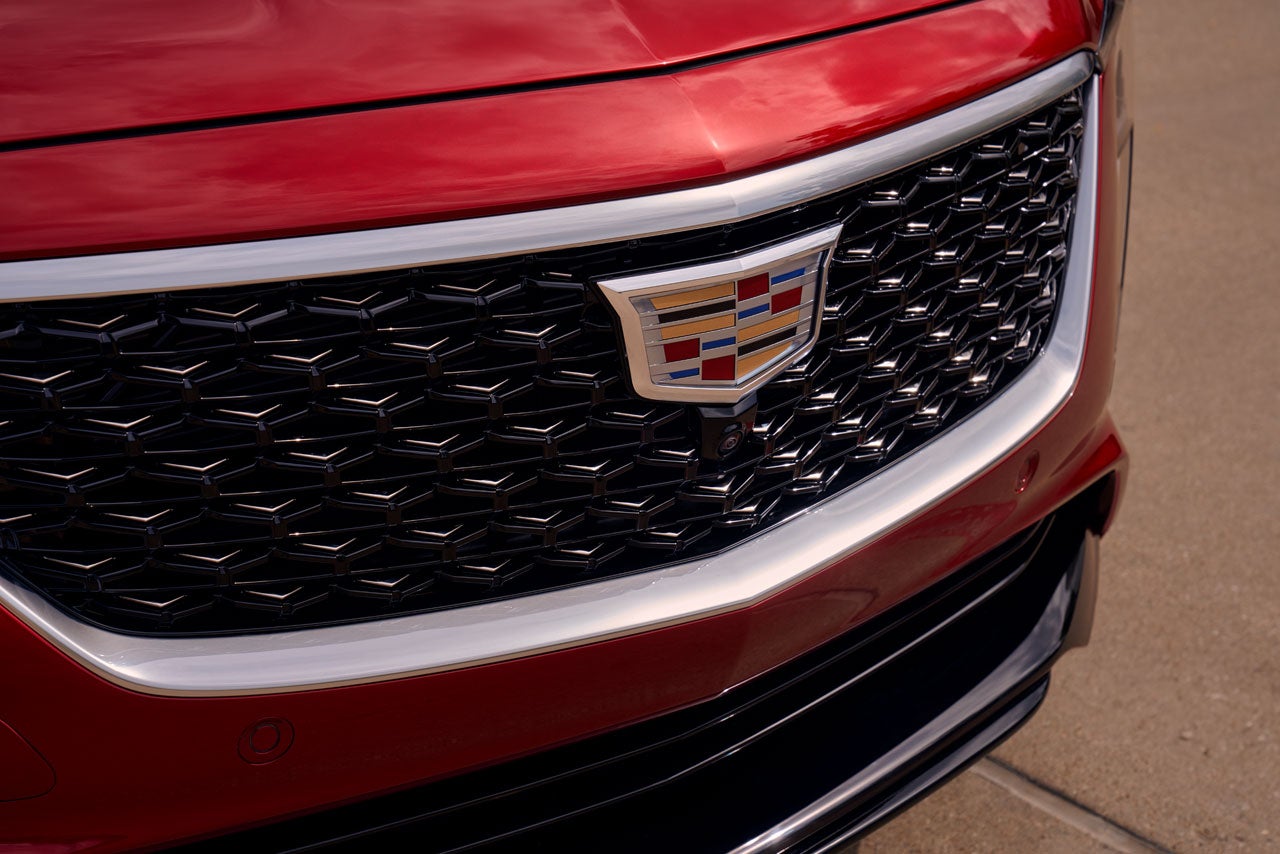 Close-up of a red Cadillac CT5-V Blackwing's front grille with the Cadillac emblem and a camera.