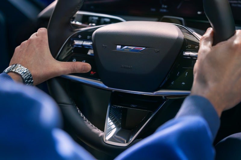 Close-up of a Man About to Press the V-Button on the 2026 OPTIQ-V Steering Wheel | Marvin K. Brown Cadillac in San Diego CA